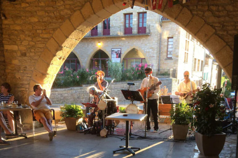 Festive outdoor gathering under evening lights during Villefranche-du-Perigord summer music nights celebration